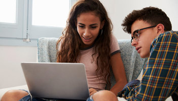 19343027 Teenage Couple Looking At Laptop Computer Together At Home