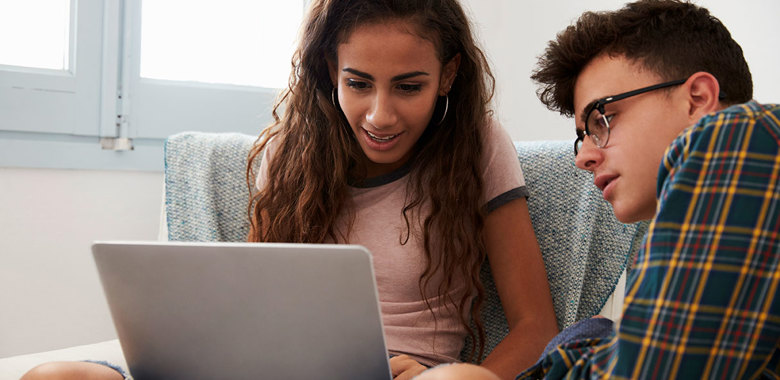 19343027 Teenage Couple Looking At Laptop Computer Together At Home