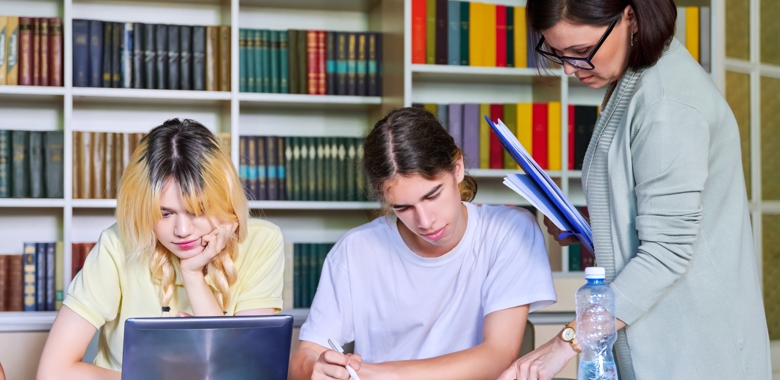 55224012 Girls Teenage Students Studying In Library With Teacher