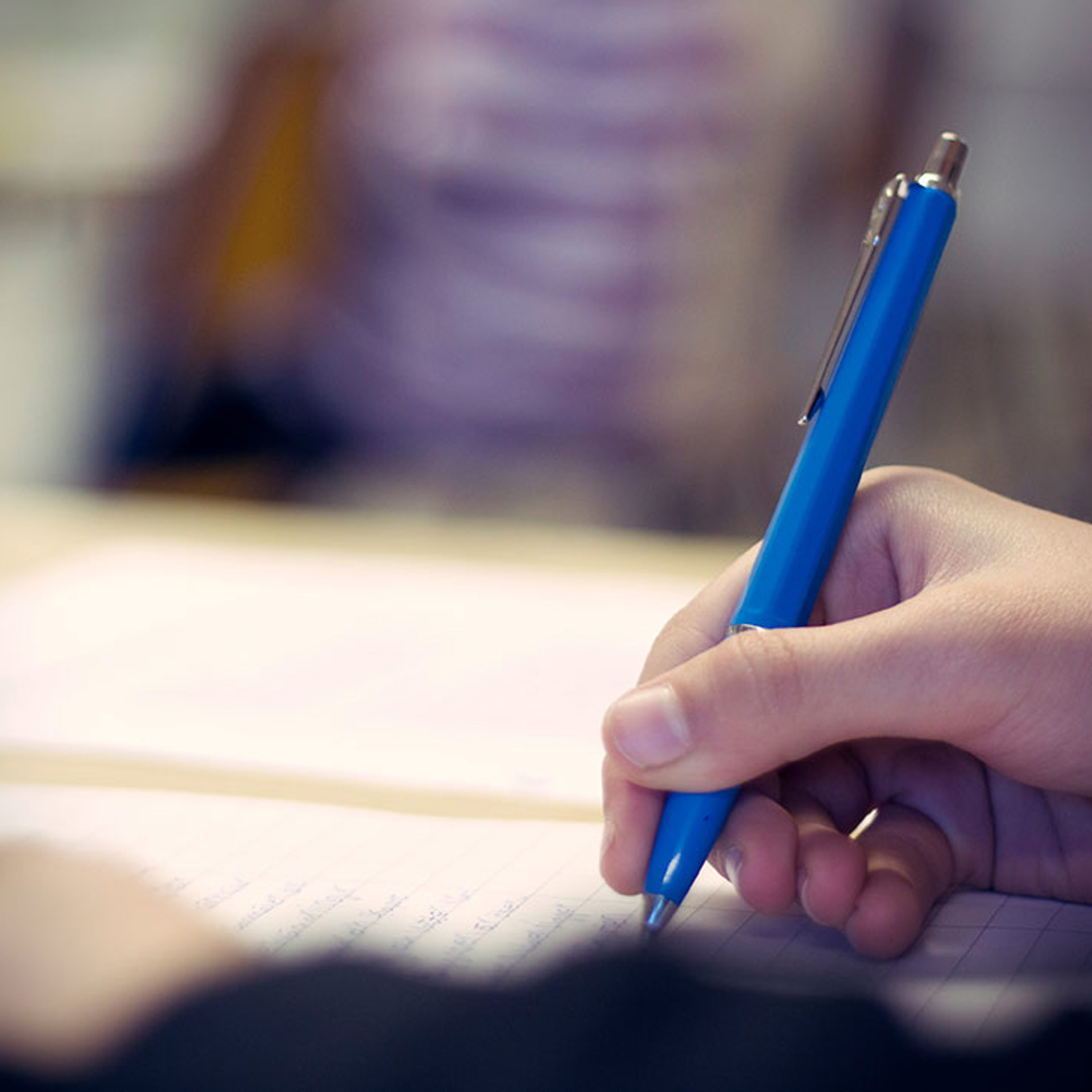 hand som skriver på papper med en penna
