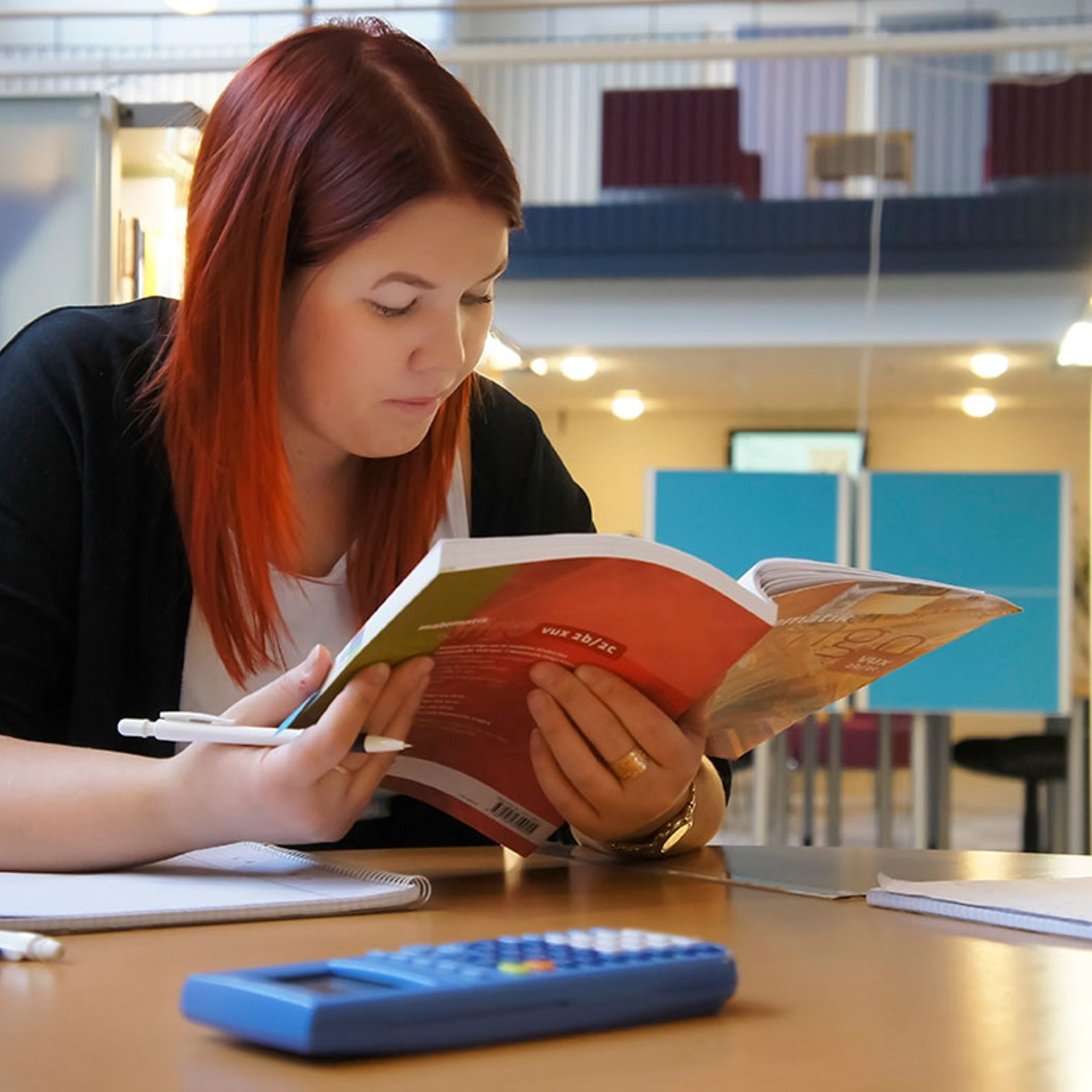 Tjej sitter och läser i en bok